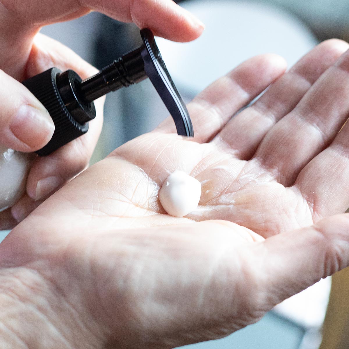 cleanser pump in hand of blue lavender cleansing milk