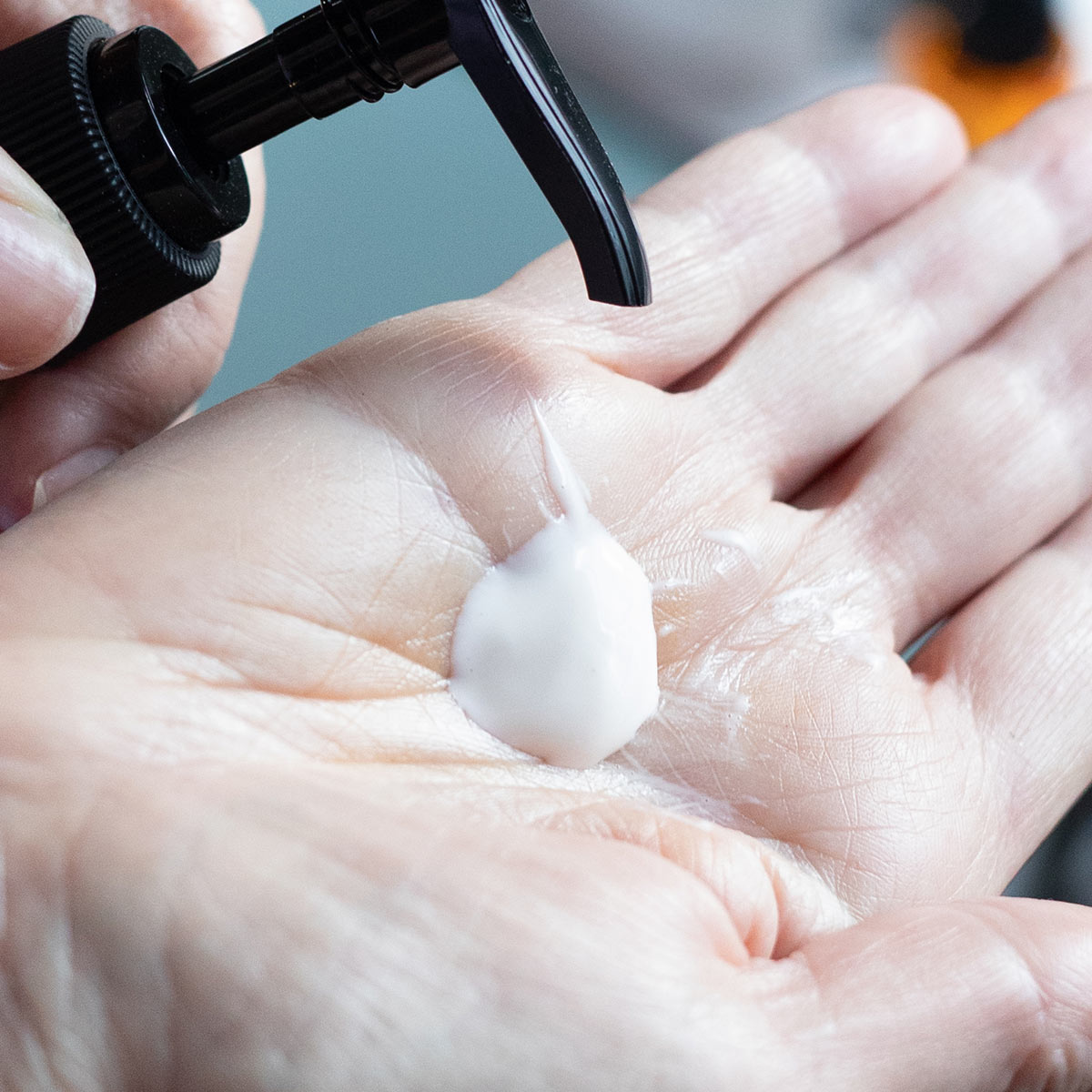 pump of creamy patchouli rose cleansing milk facial cleanser in palm of hand