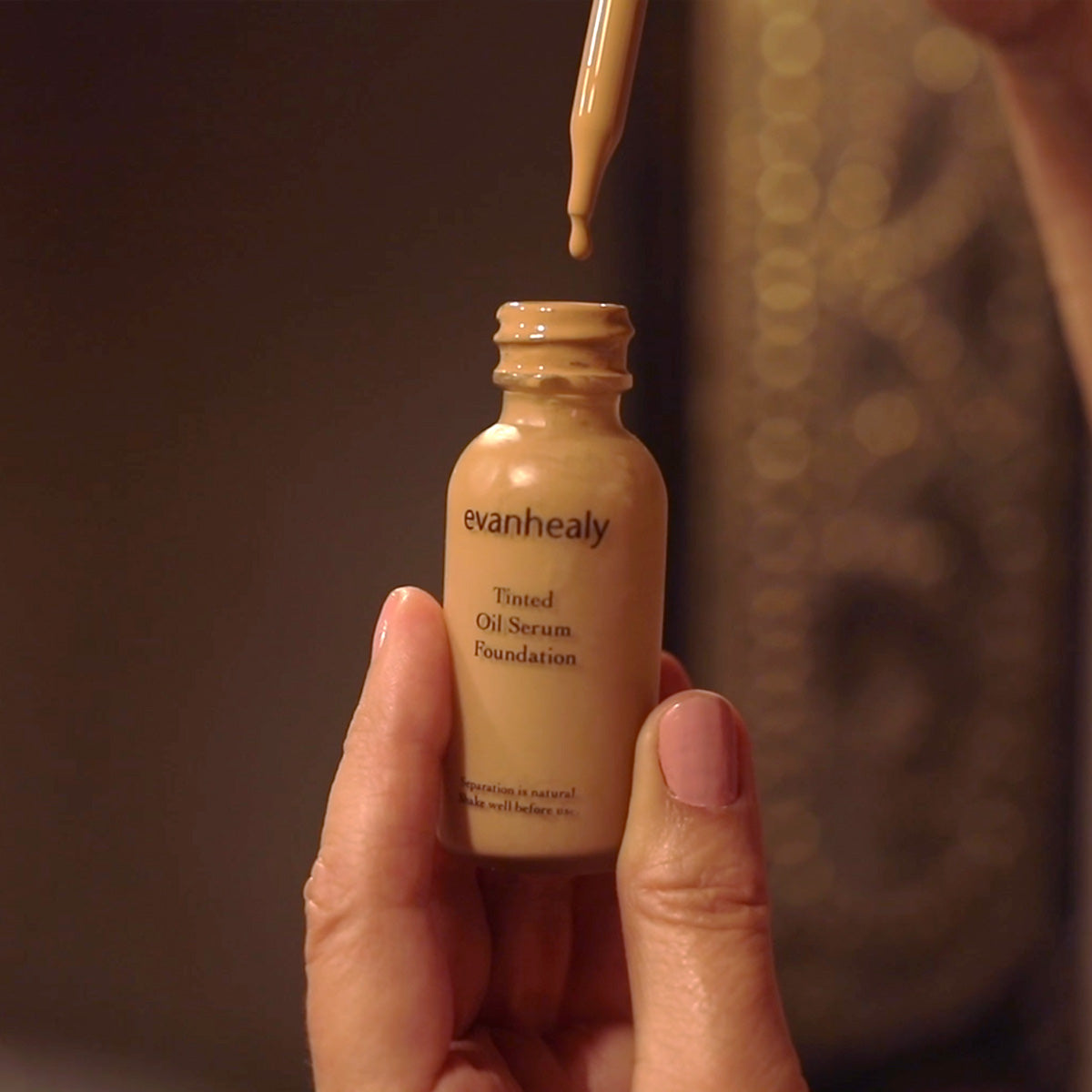 model dripping tinted oil serum foundation drops from dropper top