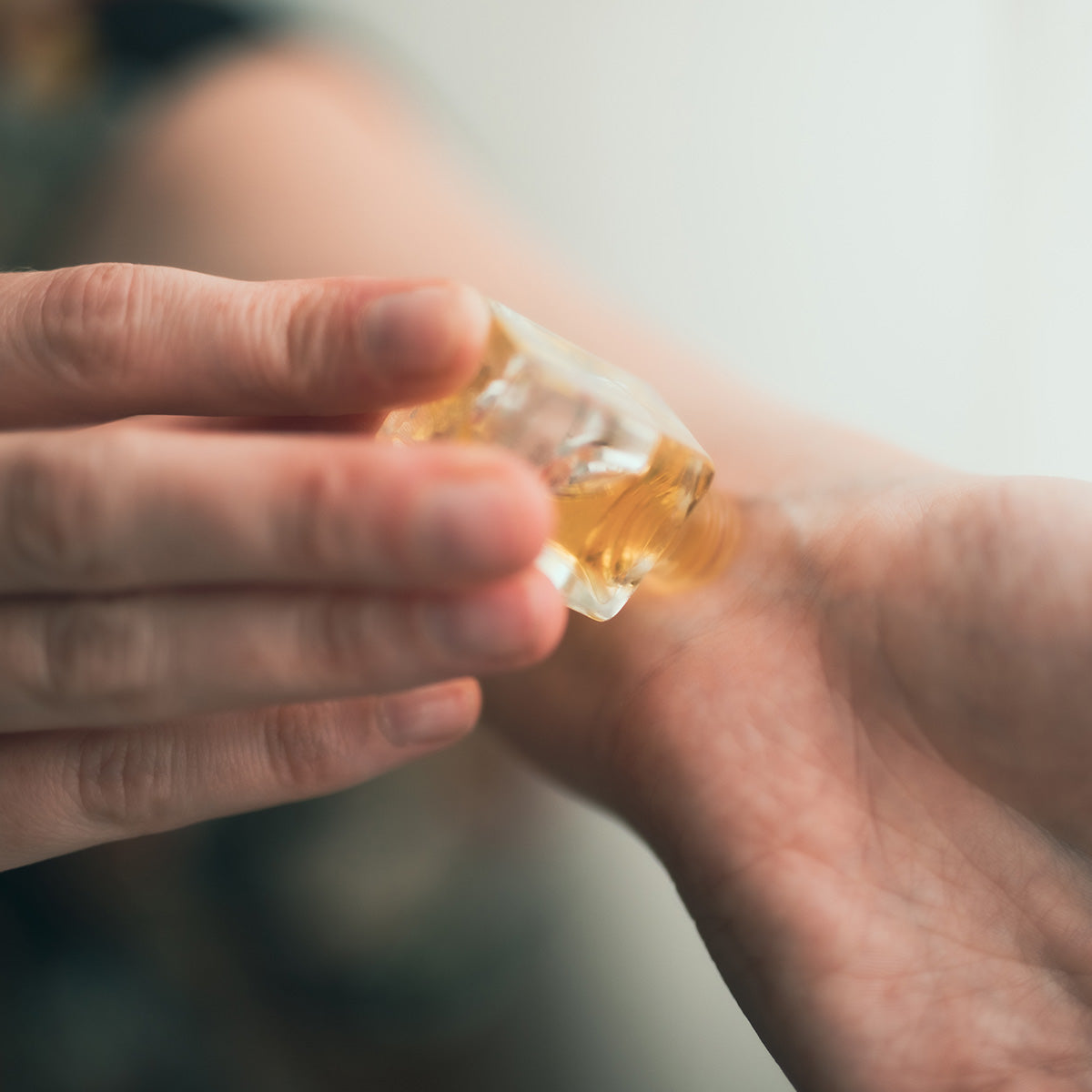 model applying jasmine perfume to wrist point