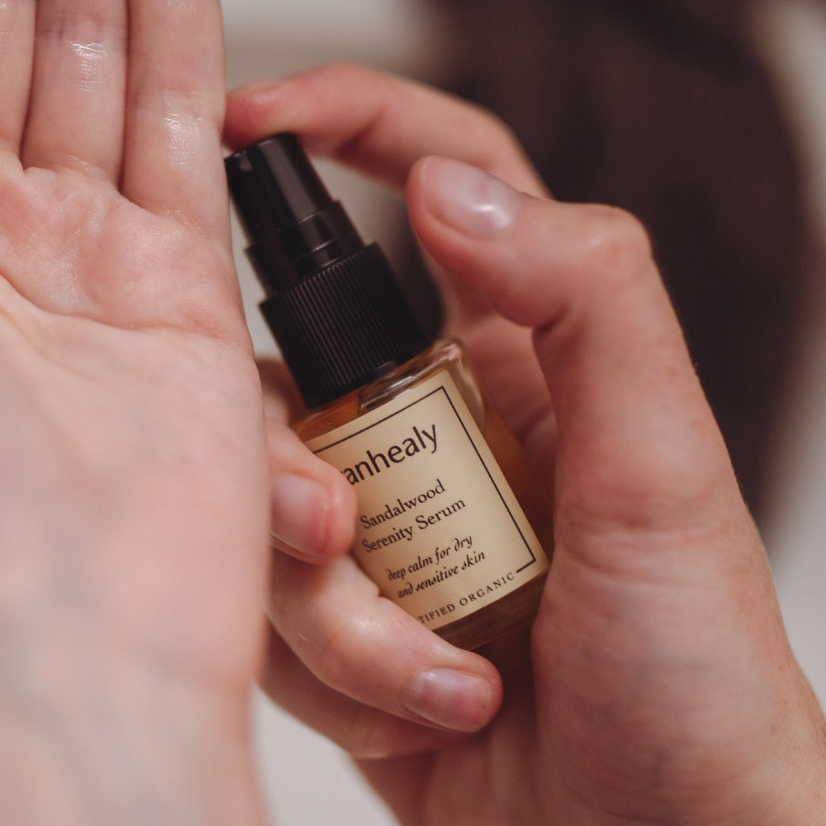 sandalwood serenity serum skin care product in models hand