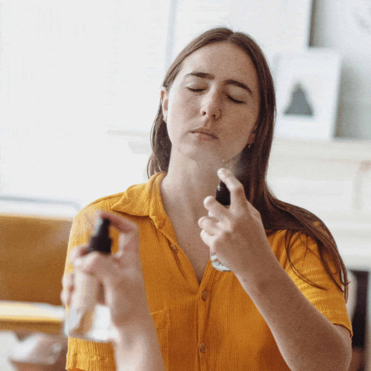 model spraying frankincense facial tonic hydrosol on face with eyes closed to refresh skin