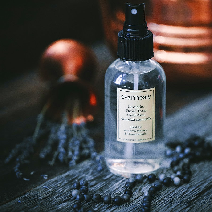 evanhealy organic lavender facial toner hydrosol on wood surface with lavender bouquet