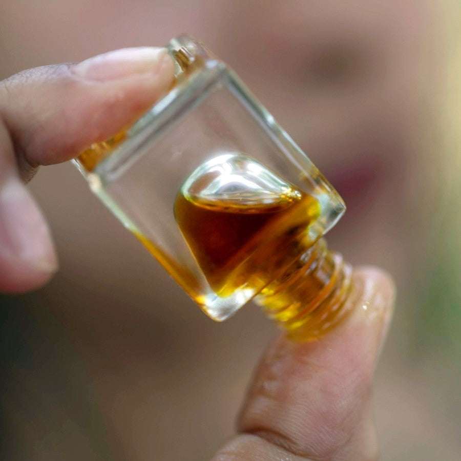 patchouli essential oil perfume tilted in fingertips