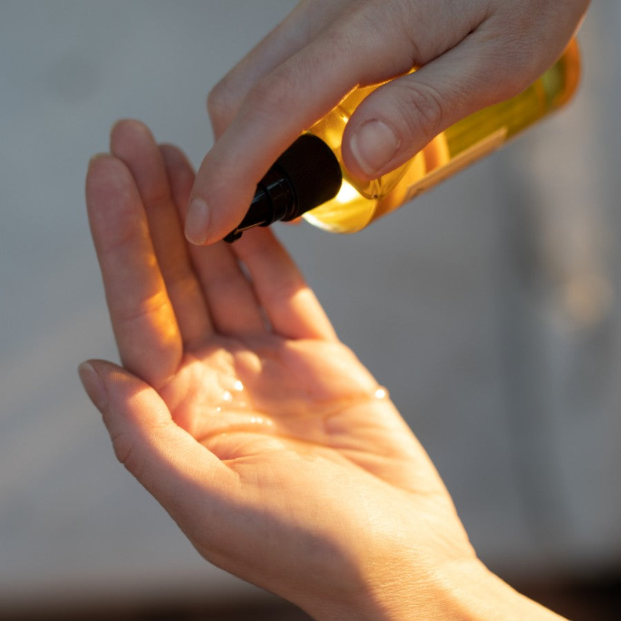 pumping sweet blossom body oil into hand