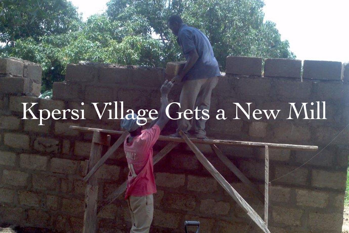 Two men building a brick wall on wooden scaffolding in a village setting