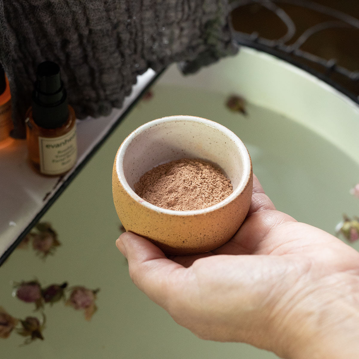 handcrafted facial clay in ceramic clay masking bowl in hand