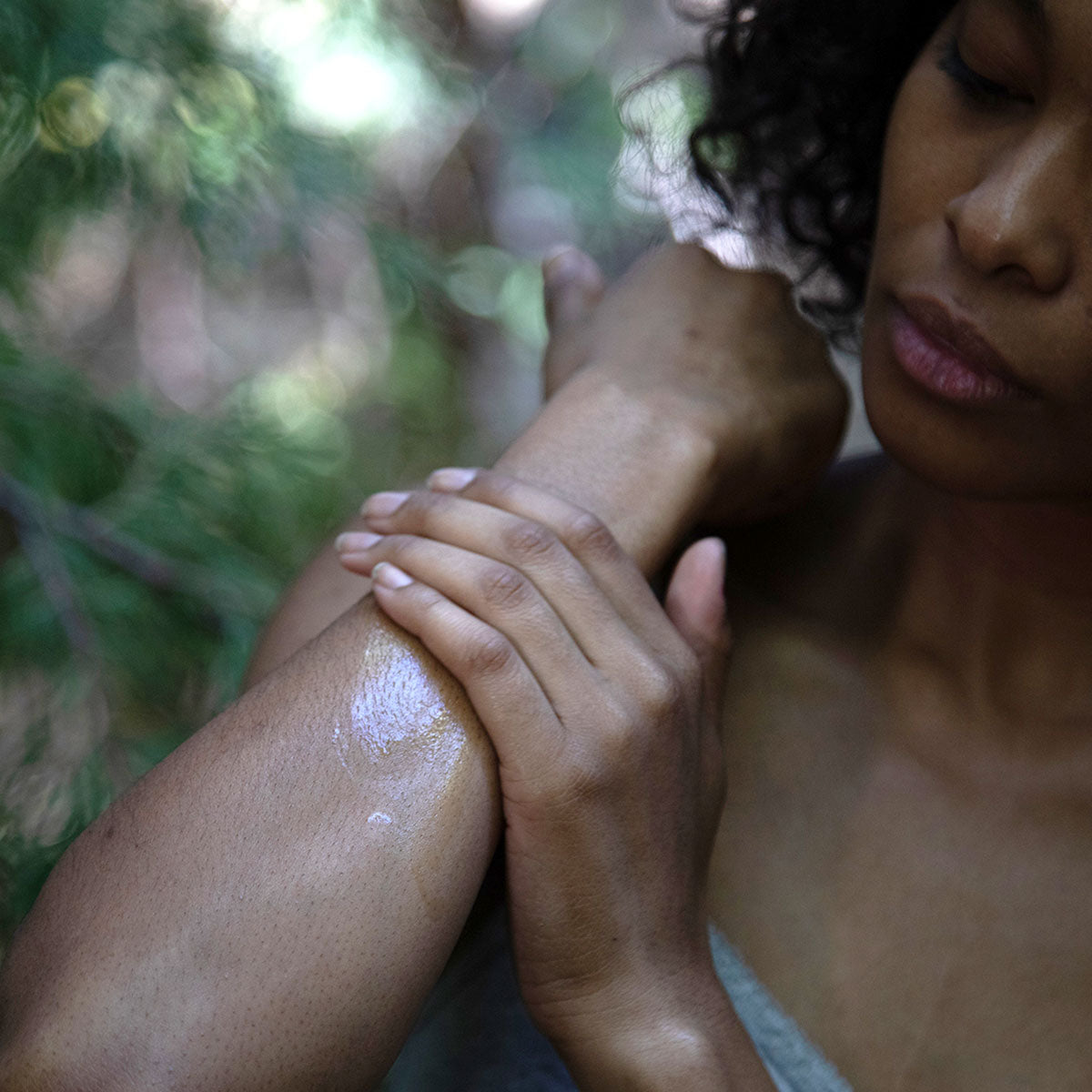 model rubbing shea butter body moisturizer on forearm