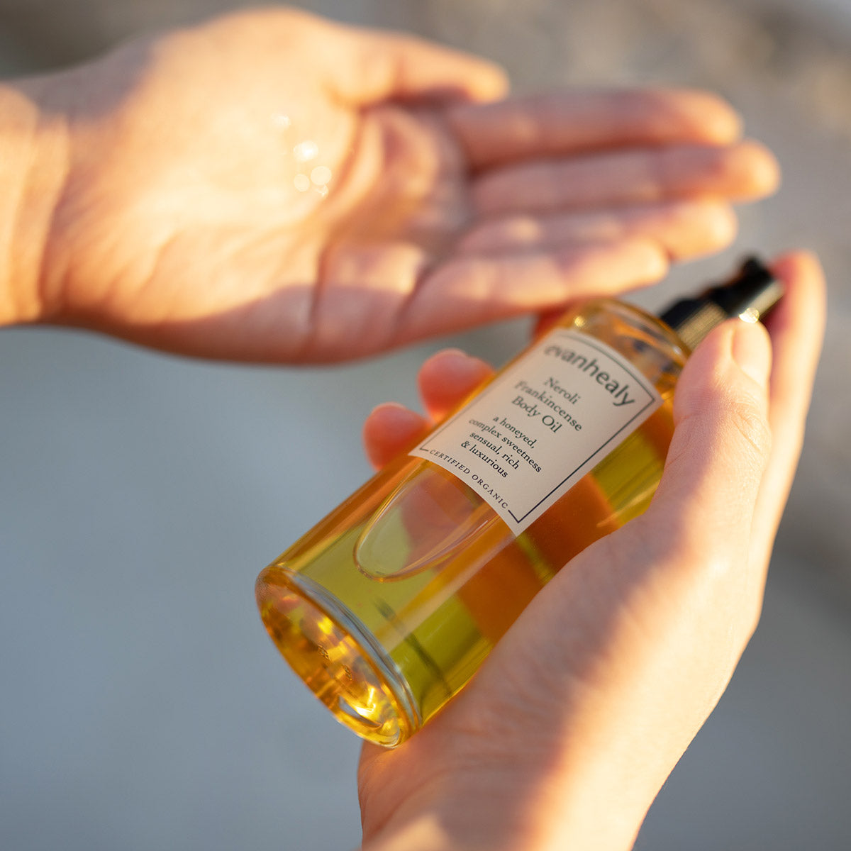 model showing bottle and texture of neroli frankincense body oil
