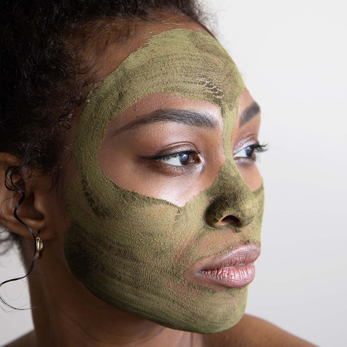 model looking to the side with evanhealy green tea clay mask drying on face