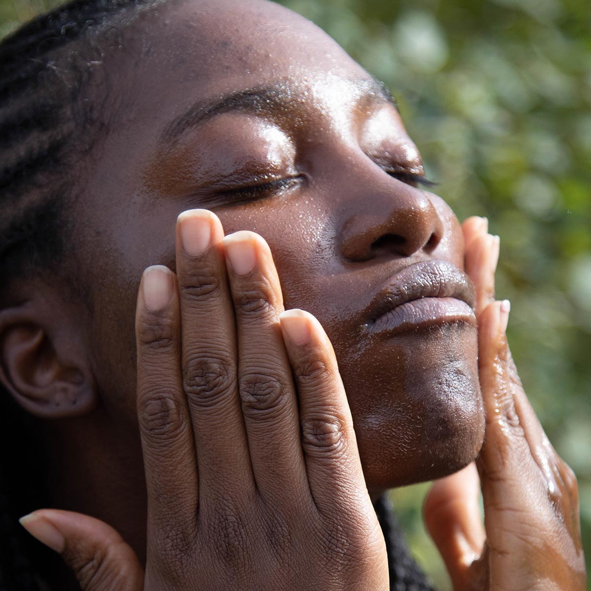 model applying nourishing cleansing oil facial cleanser to face