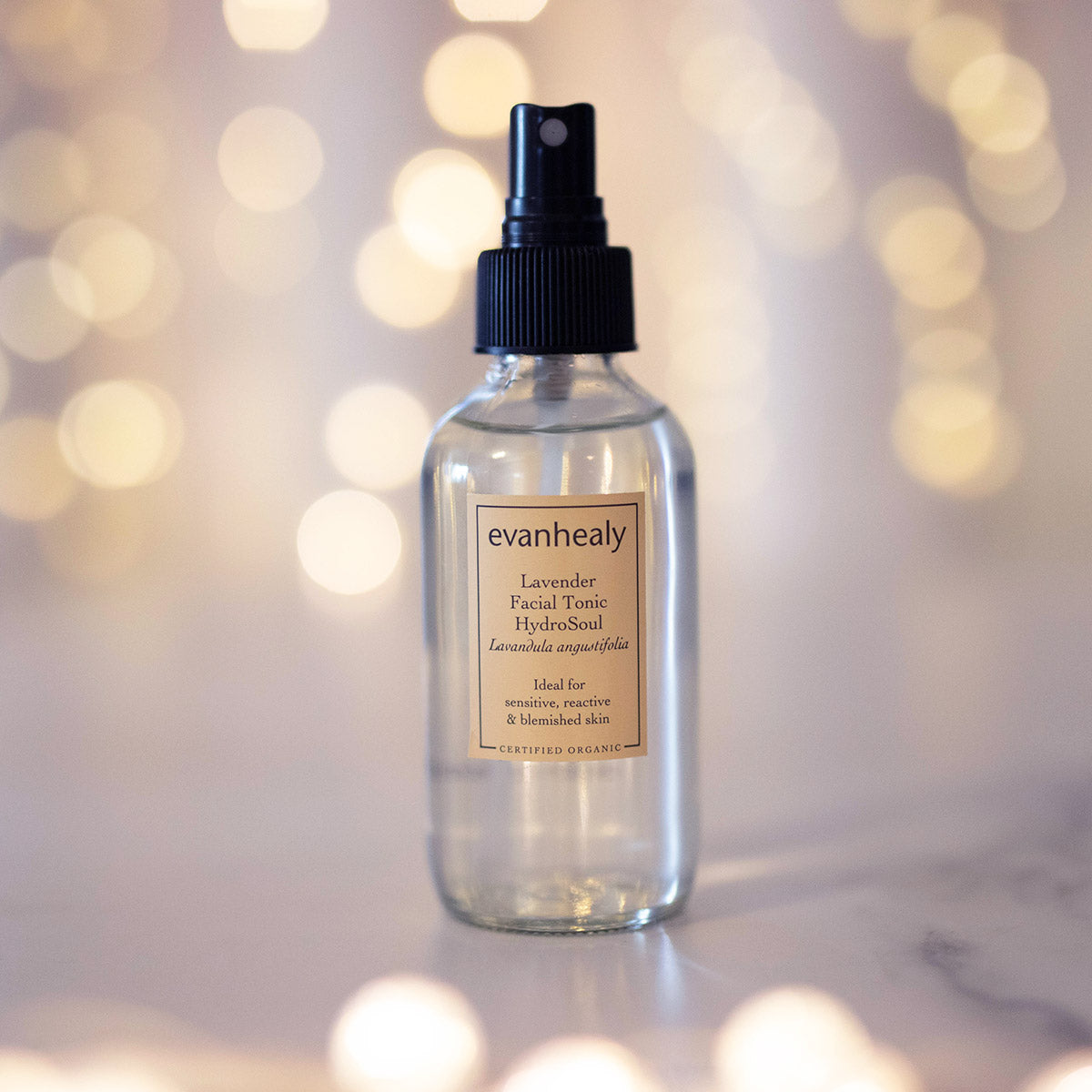 copper distilled lavender hydrosol facial toner on surface with twinkling lights
