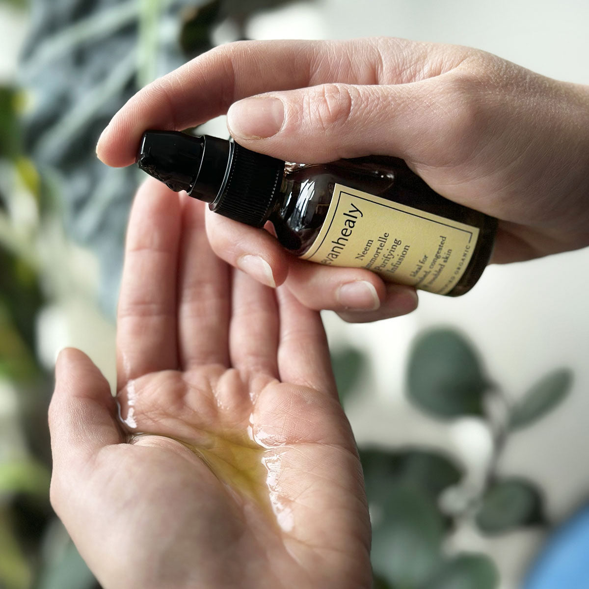 neem immortelle oil serum pump in palm of hand to show texture