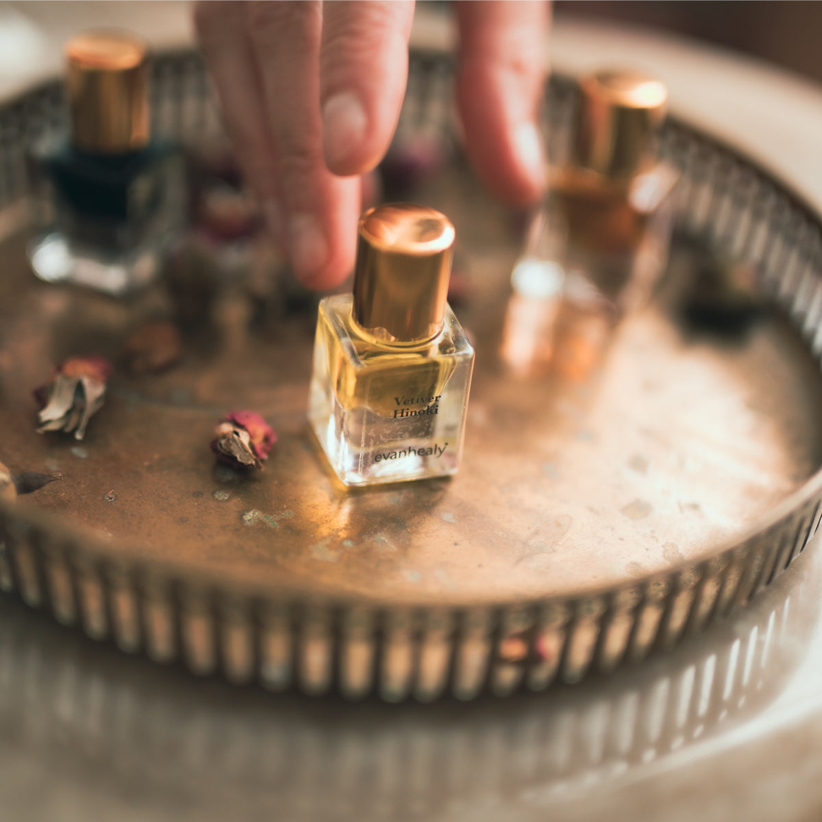 vetiver hinoki perfume on metal tray with jewelry