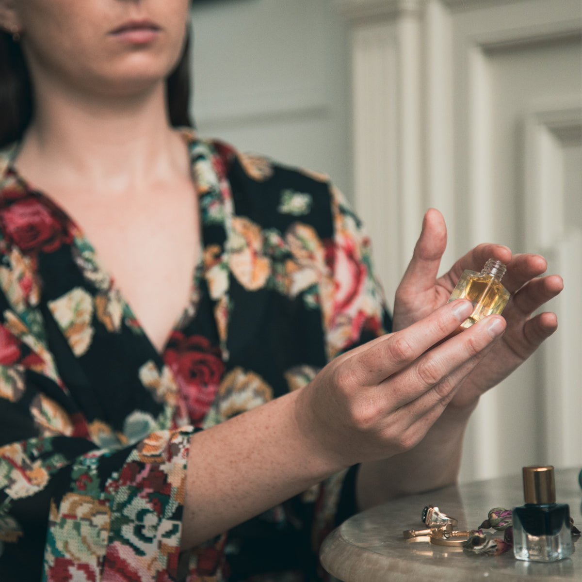 model using finger to dab jasmine perfume out of bottle