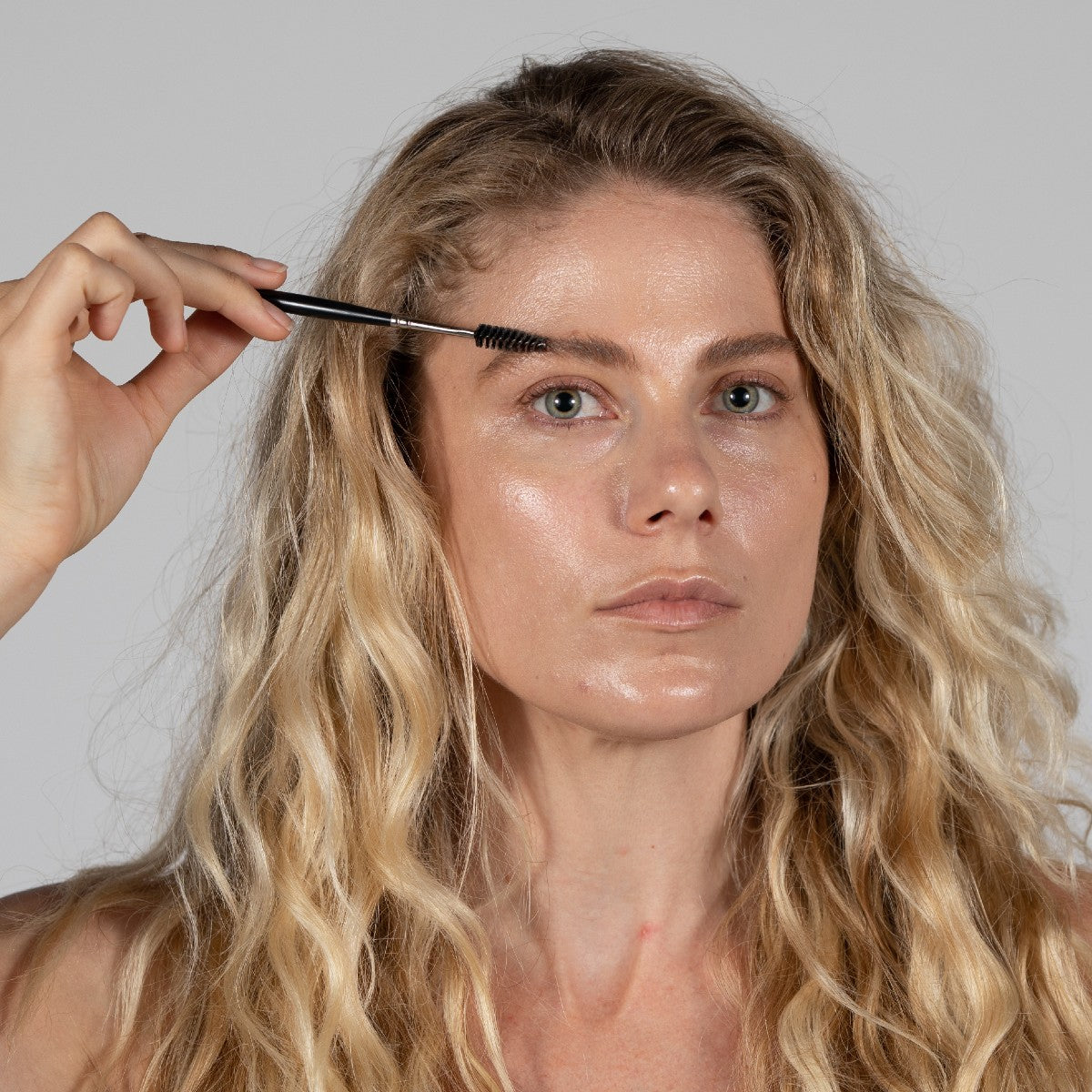 model using spoolie brush tip to comb eyebrows