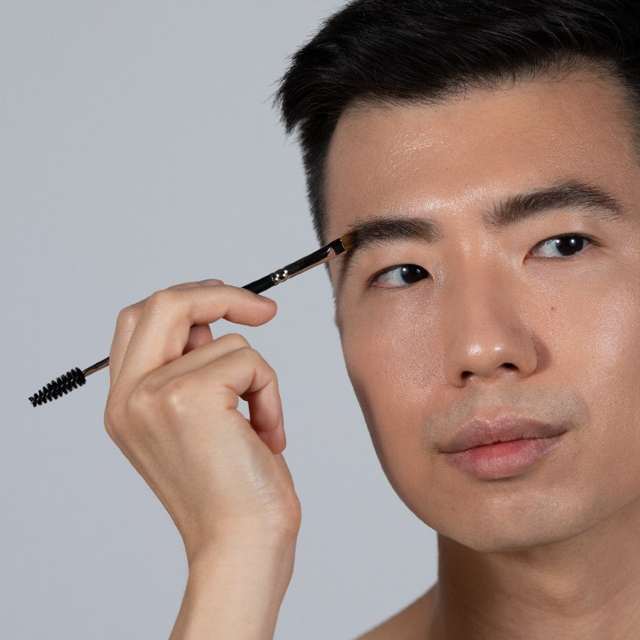 male model applying brow pomade to eyebrows with angled brush tip